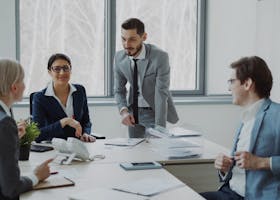 Group of professionals in a modern office setting discussing business strategies.